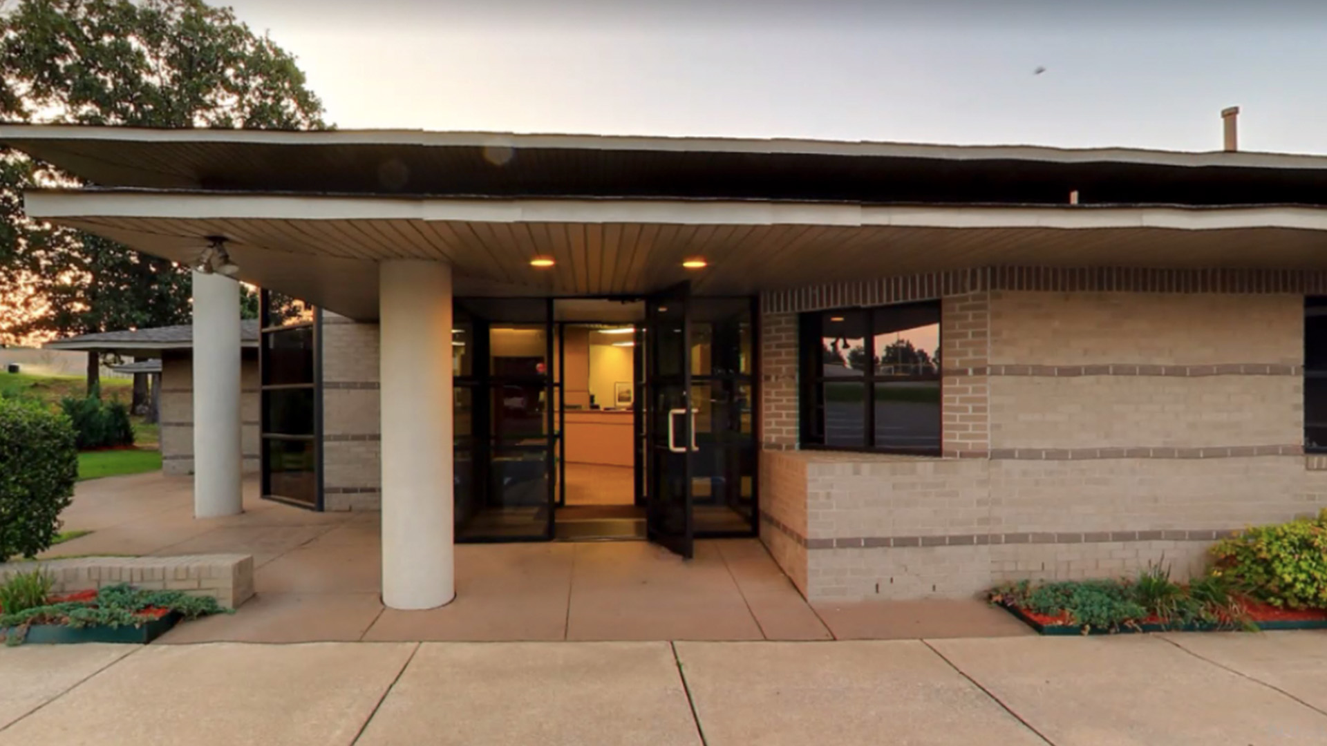 The image shows a building with a covered entrance, featuring a brick facade and a sign with the name  The Center for Healthy Aging  visible above the door.